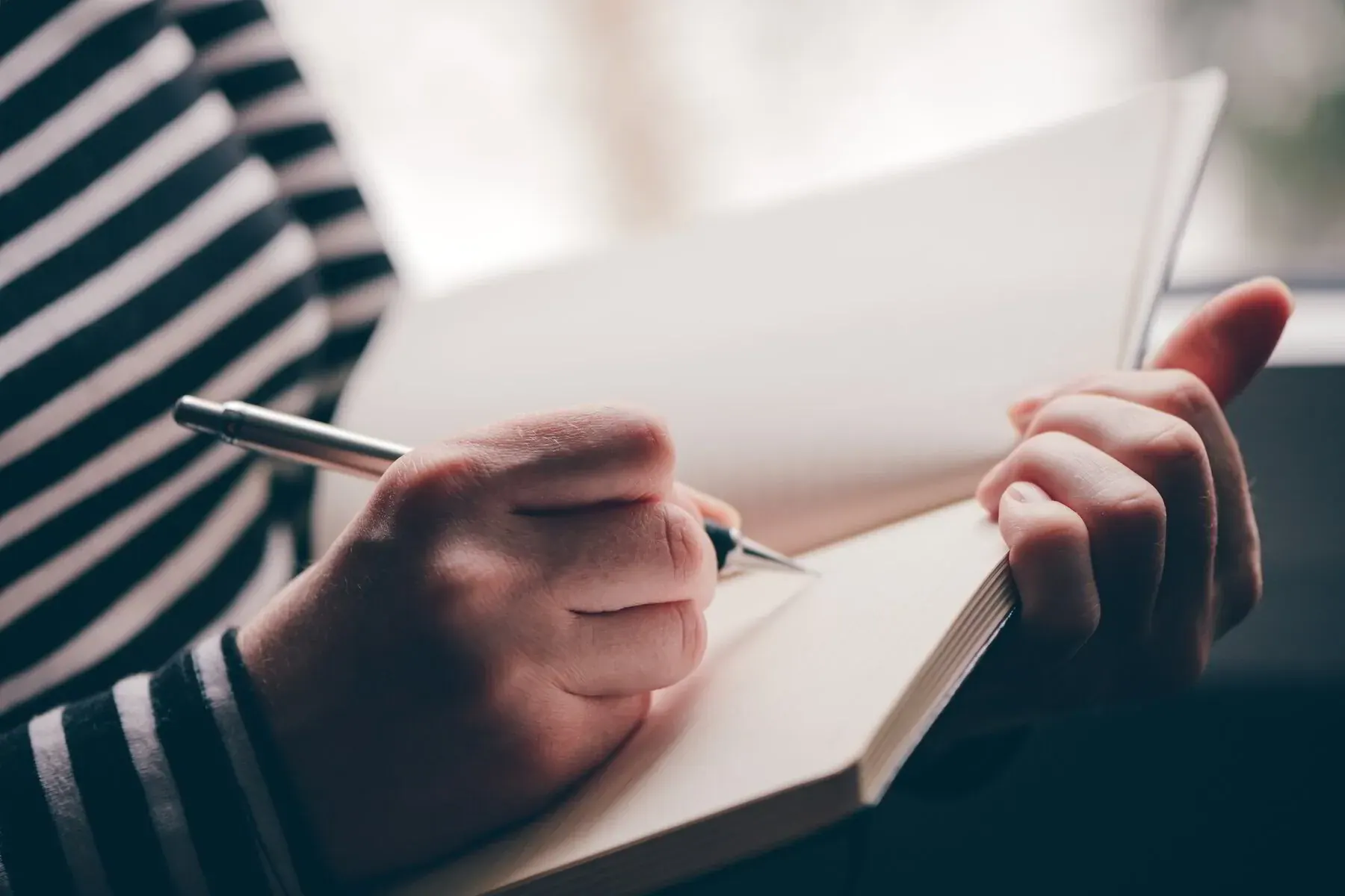 An open journal and pen representing journaling as a tool for processing grief